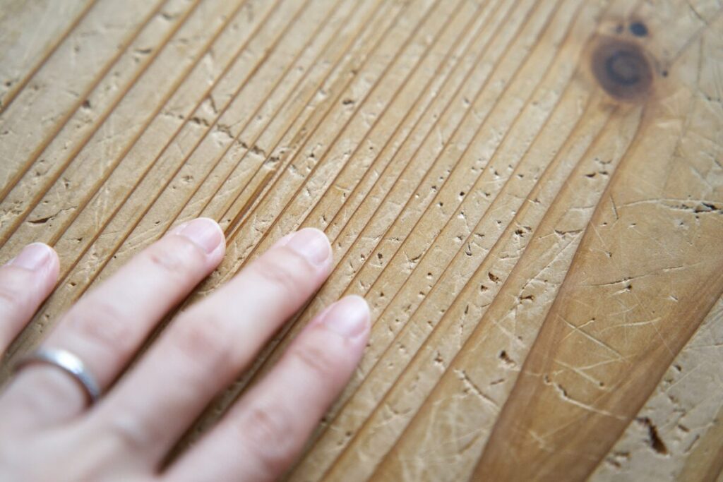 無垢材の床を手で触っているところ